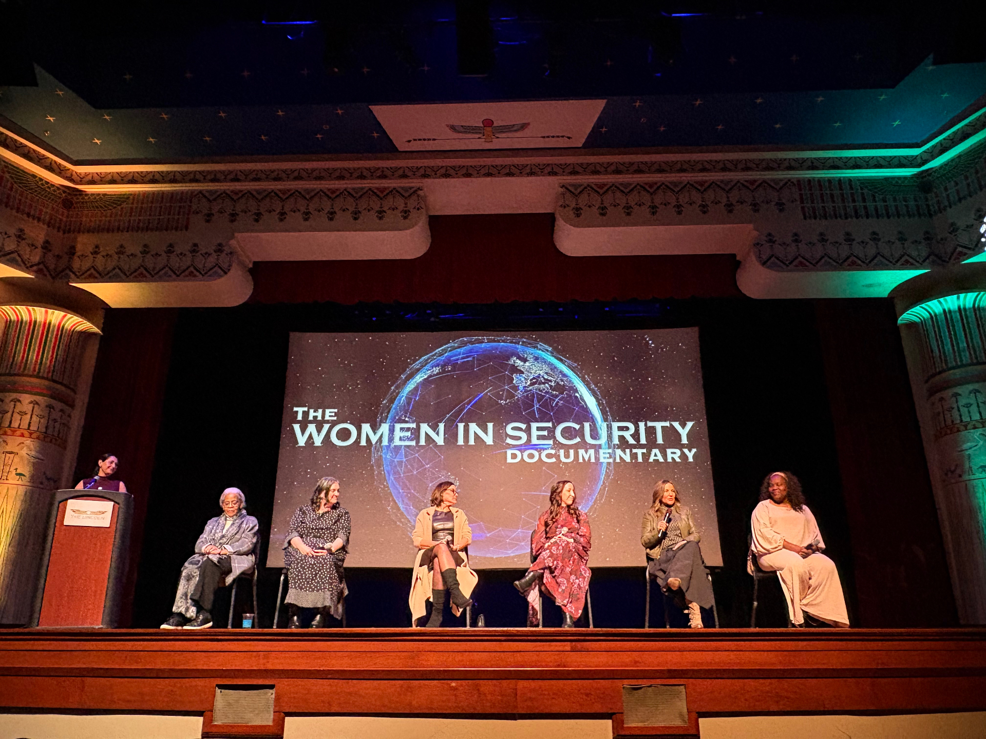 A panel discussion on the stage of a historic theater.